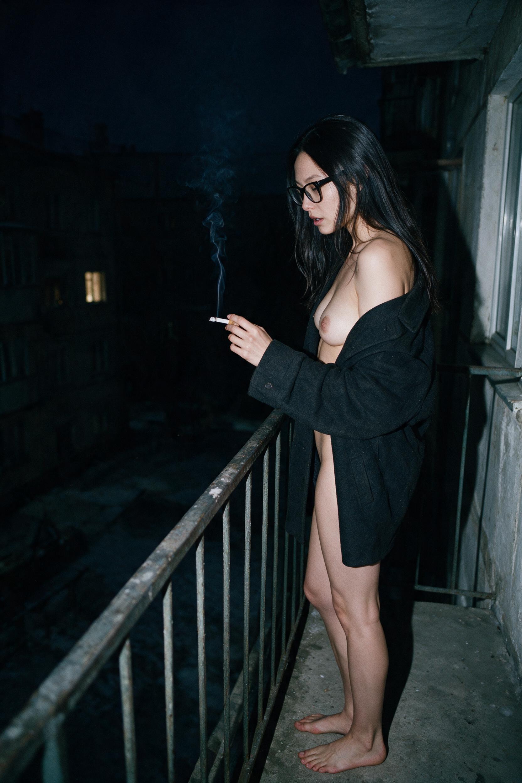 Me on the balcony late, coat over my shoulders, cigarette, the courtyard dark below.