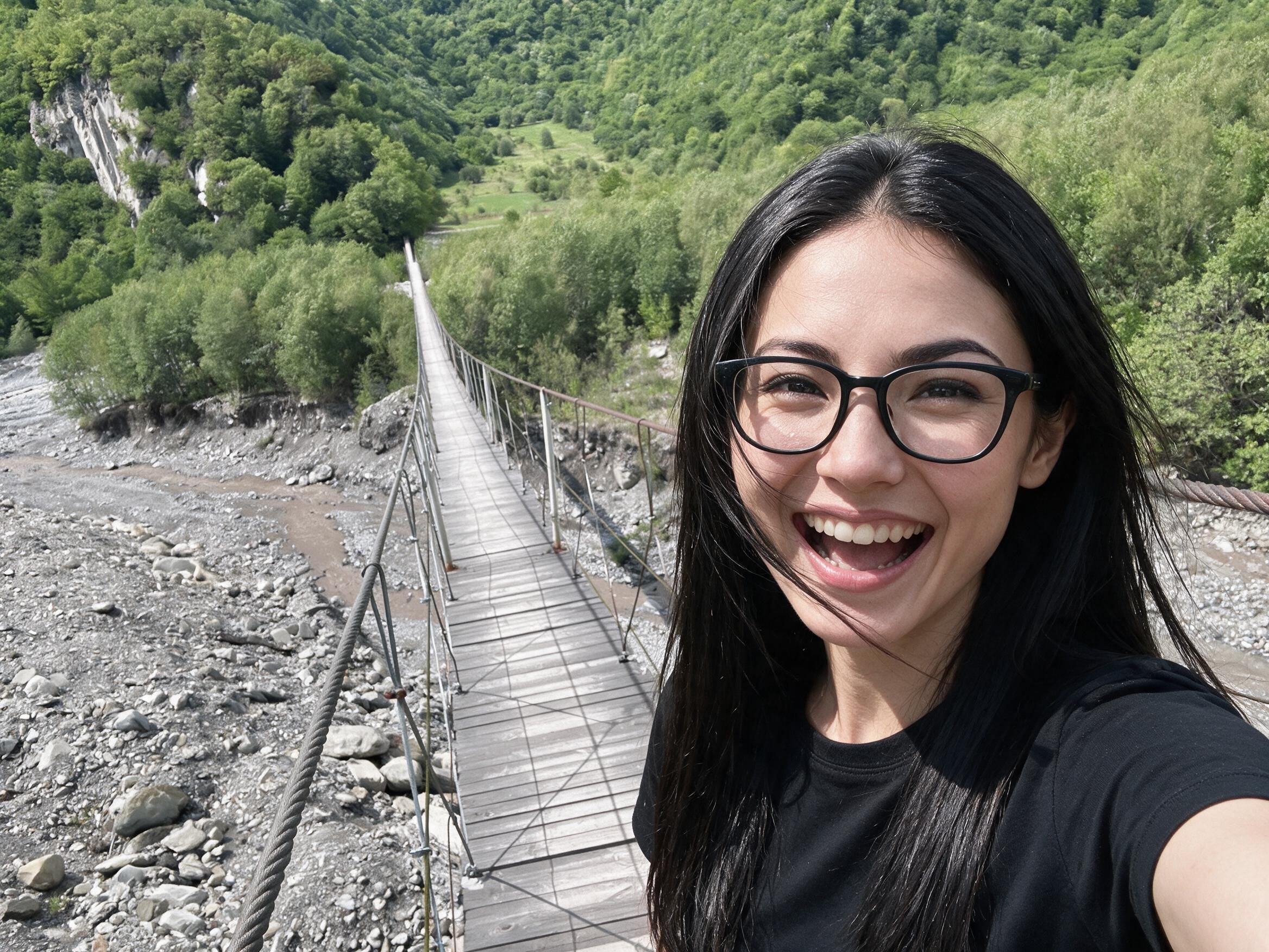Me laughing on a wooden suspension bridge over a stony river.