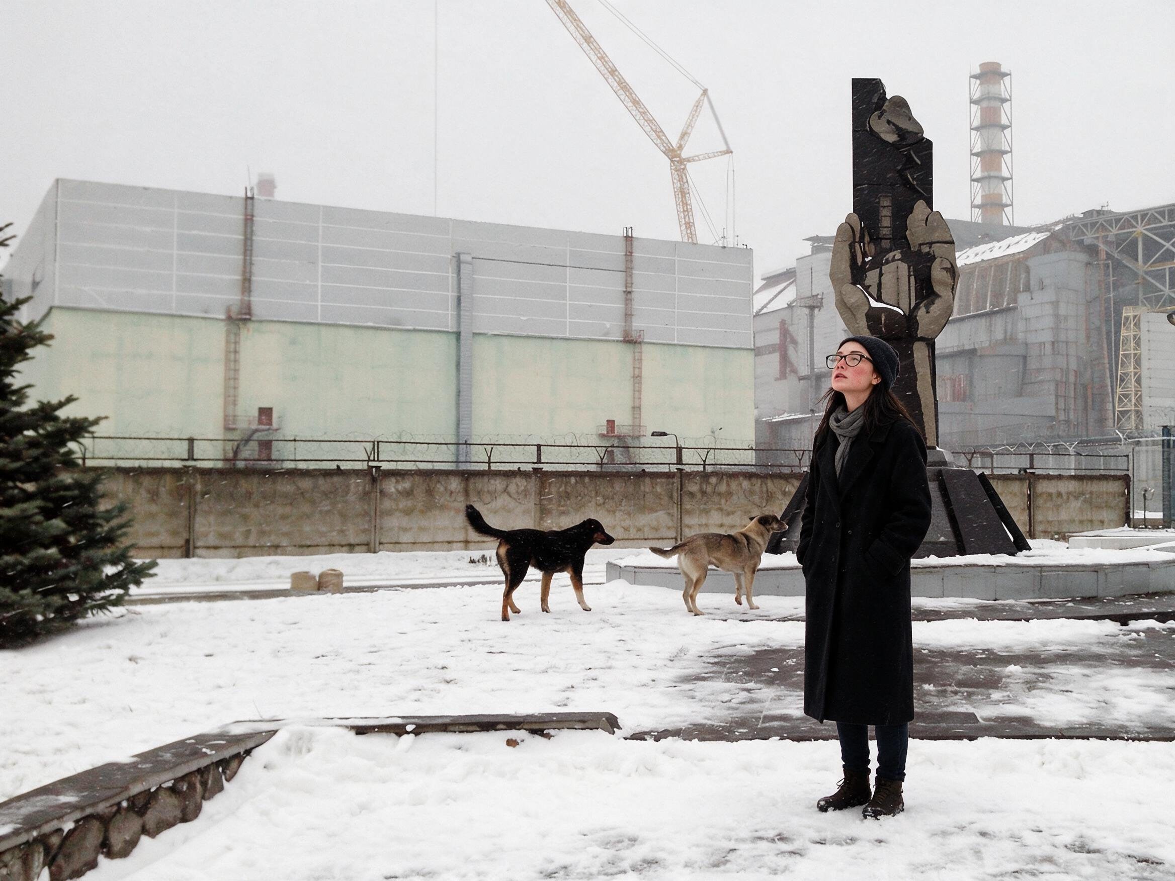 Me at the liquidators' monument near the plant, two stray dogs in the snow beside me.