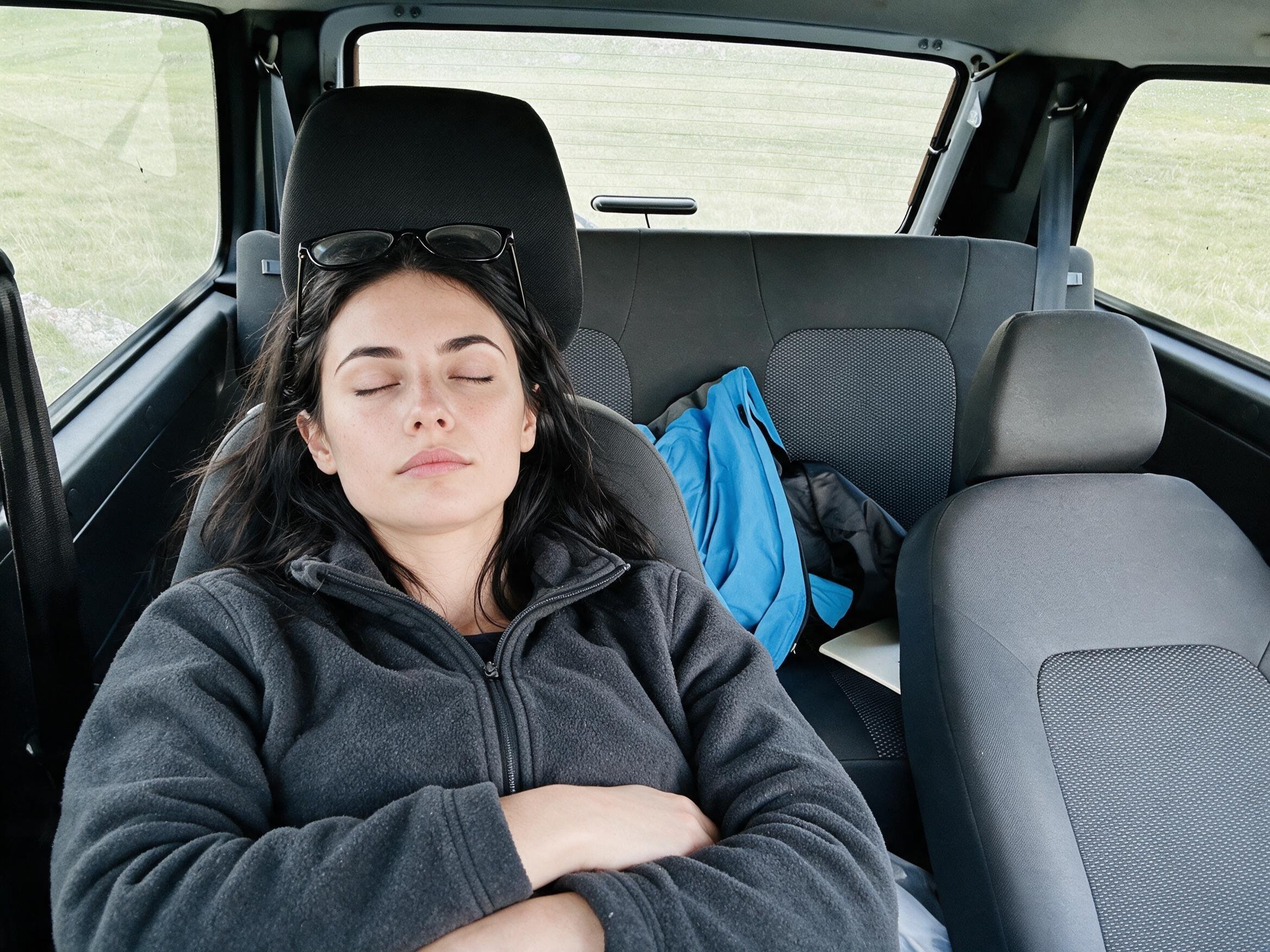 Me asleep in the reclined front seat of the Lada, glasses in the hair.